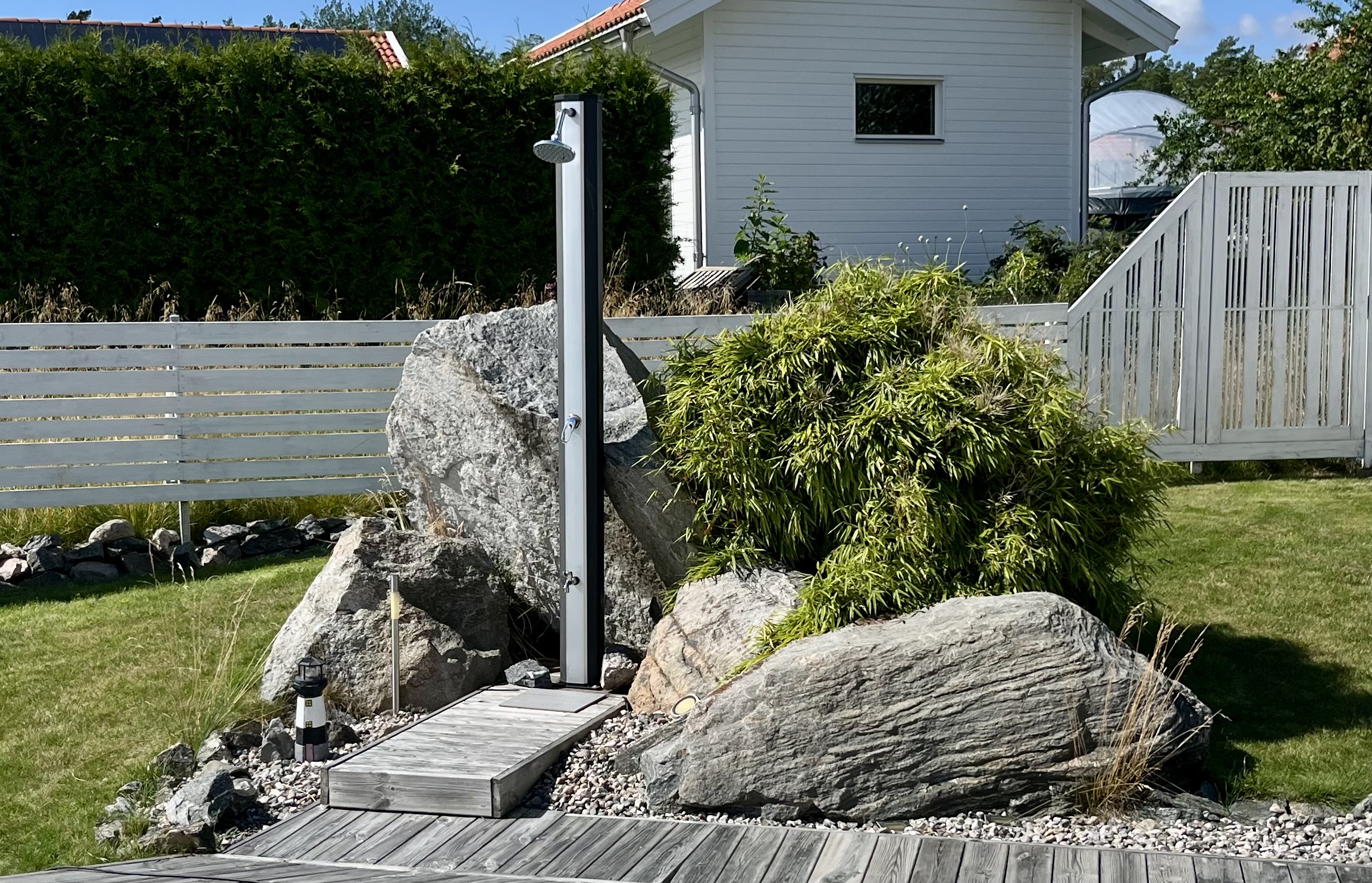 Pool med utedusch, trädgård